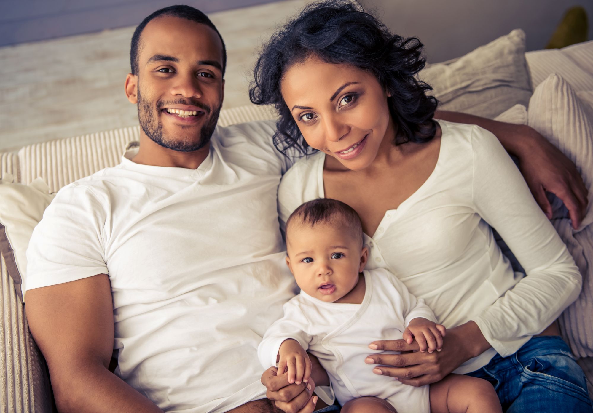 A smiling family with their baby.